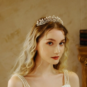 Elegant gold bridal crown with pearls and rhinestones on model in vintage setting