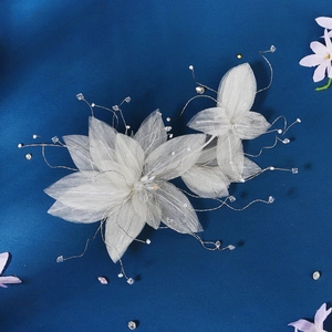 Elegant white mesh flower headband with sparkling crystals and pearls on deep blue background