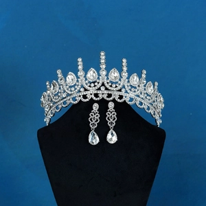 Exquisite bridal jewelry set with crystal crown and teardrop earrings on a black bust