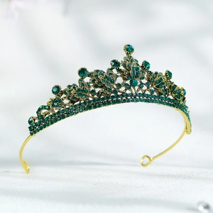 Détail de la couronne de mariée en or avec strass vert émeraude et motif de feuilles délicat