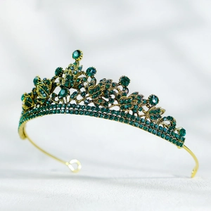 Détail macro des cristaux vert émeraude sur une couronne baroque en bronze vintage