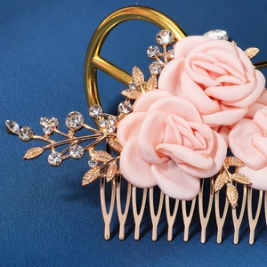 Close-up of pink satin roses and golden leaves with crystals on a wedding hair comb