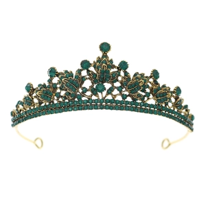 Détail d'une couronne de mariée dorée avec strass vert émeraude et motifs de feuilles