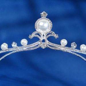 Elegant silver bridal crown with white pearls and sparkling rhinestones on blue silk