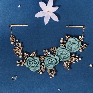 Detail of blue satin roses and gold alloy leaves with sparkling rhinestones on the bridal comb