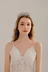 Close-up of sparkling silver bridal crown with intricate crystals on lace wedding dress