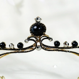 Close-up of golden vintage bridal crown featuring black pearls and rhinestones detail