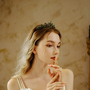 Couronne de mariée baroque avec cristaux verts et métal bronzé sur un mannequin