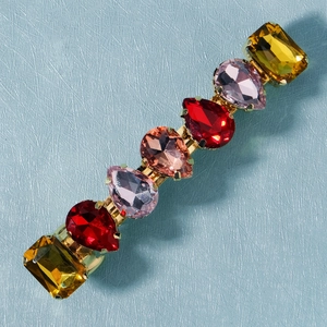 Detailed macro shot of colorful mixed crystal hair clip with golden alloy base