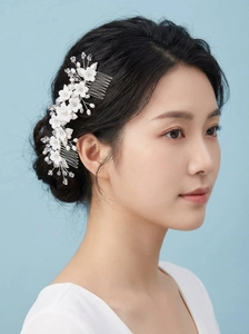 Détail d'un peigne à cheveux de mariée avec fleurs en céramique et perles de cristal