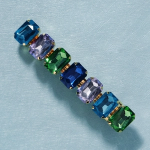 Detail view of colorful emerald-cut rhinestones set in a golden spring hair clip