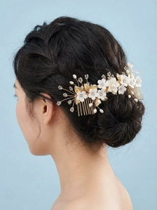 Détail du peigne de mariée avec fleurs en céramique blanches, feuilles d'or et cristaux