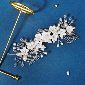 Détail du peigne à cheveux en céramique blanche avec perles et strass sur fond bleu