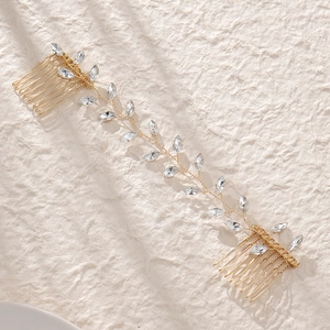 Détail macro d'un peigne de mariée avec cristaux en vigne et fil doré sur tissu doux
