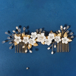 Détail du peigne à cheveux de mariée avec feuilles d'or, fleurs et perles