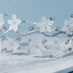 Handmade bridal headband with white matte flowers and crystal beads on a satin frame