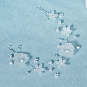 Détail de serre-tête fait main avec perles, fleurs en résine et fil d'argent