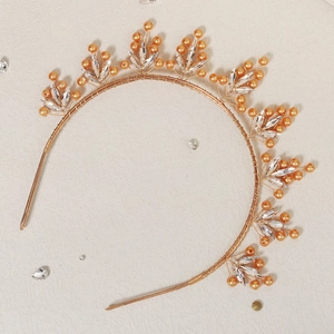 Détail d'un serre-tête doré fait main orné de perles oranges et de cristaux en forme de feuilles