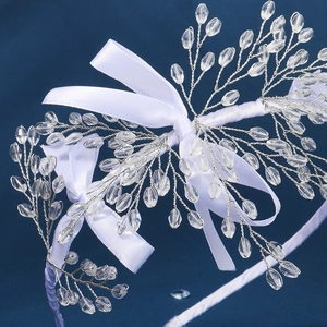Détail macro du serre-tête en cristal fait main avec nœuds blancs et fils argentés