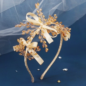 Détail d'un serre-tête artisanal en perles dorées avec un nœud élégant et cristaux
