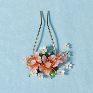 Détail d'épingle à cheveux chinoise avec fleurs de pêcher et tiges dorées artisanales
