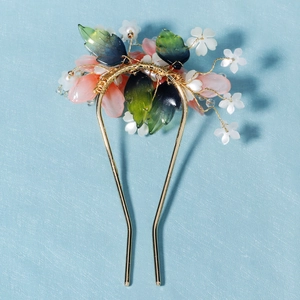 Détail d'une épingle à cheveux en U avec pétales de fleurs en résine et fils dorés