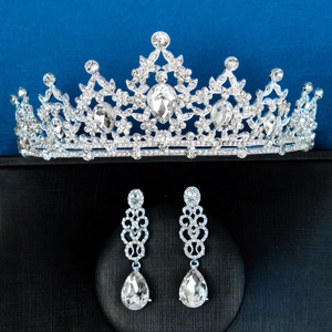 Nahaufnahme von Brautkrone und Tropfenohrringen mit Kristallen und Steinen in Birnenform