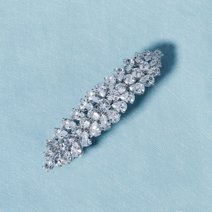 Détail de la barrette en argent avec pierres en zircone sur fond bleu clair texture