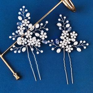 Détail d'épingles à cheveux de mariée avec perles blanches et cristaux sur fond bleu