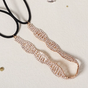 Dettaglio di fascia per sposa con strass oro rosa a onde e elastico nero