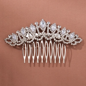 Détail d'un peigne à cheveux de mariée argenté avec strass sur un tissu texturé brun