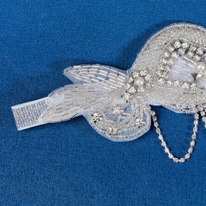 Détail d'un bandeau de mariée fait main avec perles, strass et pampilles argentées