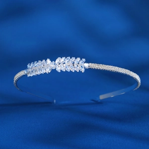 Détail d'un serre-tête argenté avec cristaux marquise sur un fond en satin bleu soyeux