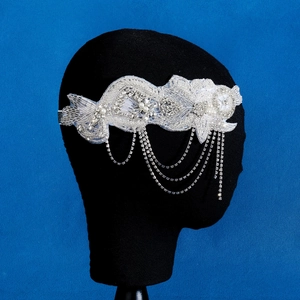 Détail d'une coiffe de mariée faite main avec glands argentés et broderies de perles