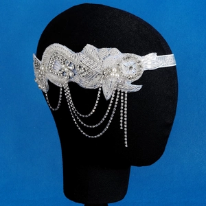 Détail d'un bandeau de mariée vintage avec perles, paillettes et pompons argentés