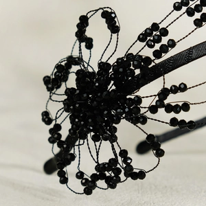 Macro shot of handcrafted black beaded flower headband with faceted crystal details