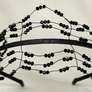 Close-up of handmade black beaded crown with intricate metal wire weaving and Gothic crystals