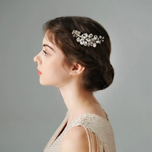 Detailed view of silver bridal hair comb with rhinestones styled on a bride's bun