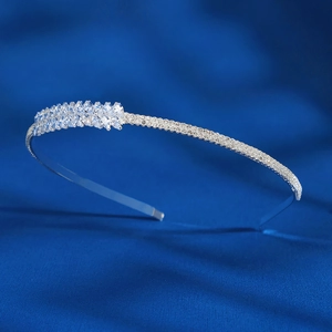 Detailed close-up of a silver headband with sparkling zircons on a dark silk background