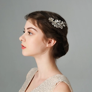 Detailed view of silver crystal bridal hair comb with leaf design on bride's updo