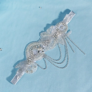 Détail d'un bandeau de mariée avec perles faites main, strass et franges argentées