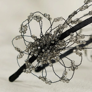Close-up of handmade black floral headband with grey crystal beads and intricate wirework
