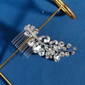 Handmade bridal hair comb with silver wire and sparkling crystals on a deep blue background