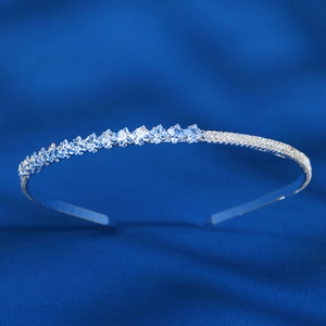 Detailed view of silver bridal headband with square rhinestones on blue silk background