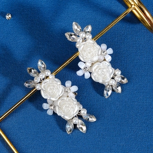Eleganti clip per scarpe a rosa bianca con perle e strass su sfondo blu intenso
