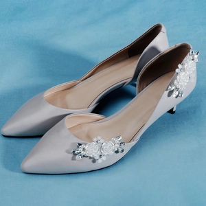 Dettaglio di fermagli per scarpe rimovibili con fiori di perle e cristalli su tacchi grigi