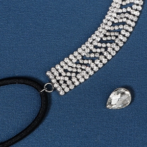 Close-up of multi-row silver crystal headband with elastic black hair tie and teardrop gem