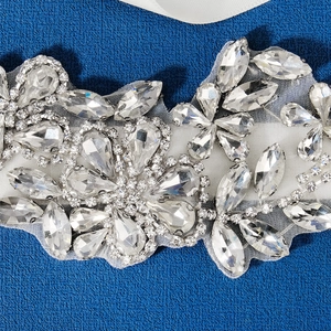 Close-up of bridal belt featuring marquise and teardrop rhinestones on white ribbon