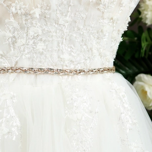 Close-up of double-row rhinestone bridal belt showing crystal detail on white lace gown