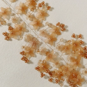 Detail of handmade bridal headband with acrylic peach flowers, pearls, and crystals